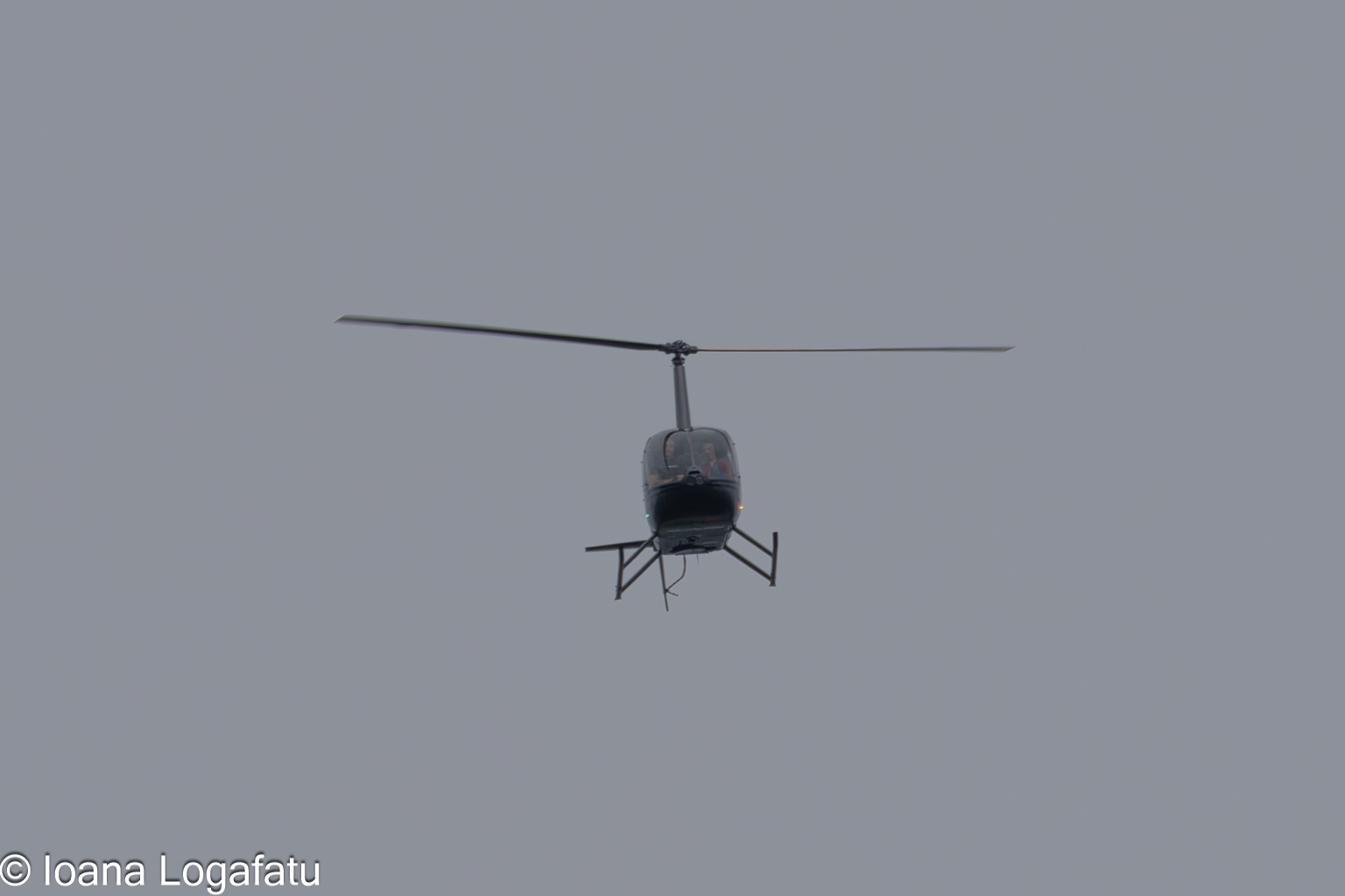 Helicopter flying through a cloudy sky over city